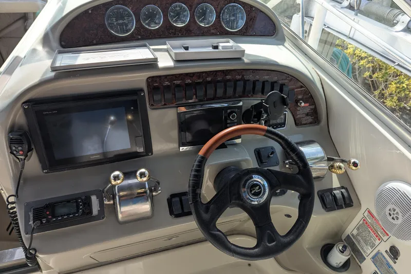 Slide: The Image of Helm of 2005 Sea Ray 290 Amberjack with steering wheel and navigation controls. - 7