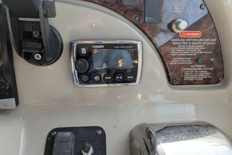 Slide: The Image of Control panel of a 2005 Sea Ray 290 Amberjack boat with warning labels and audio system. - 8