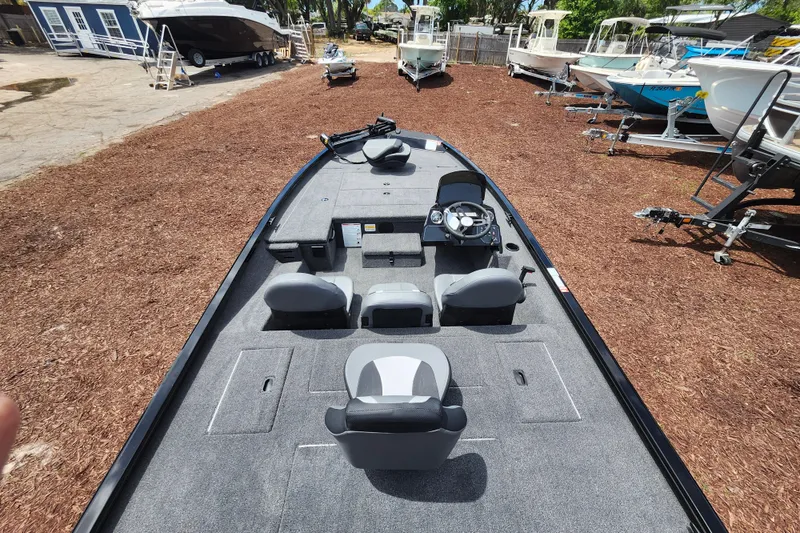 Slide: The Image of 2026 Lowe Stinger 175C fishing boat with spacious deck and modern seating, parked outdoors. - 10