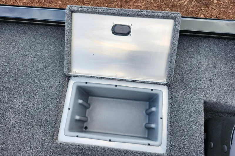 Slide: The Image of Open storage compartment on 2026 Lowe Stinger 175C boat, featuring gray carpeted interior. - 15