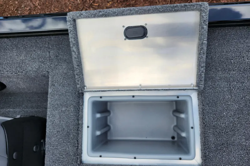 Slide: The Image of Open storage compartment in 2026 Lowe Stinger 175C boat, featuring gray carpeted interior. - 17
