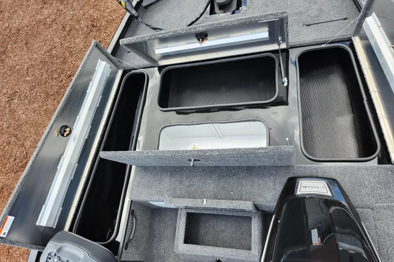 Slide: The Image of 2026 Lowe Stinger 175C boat interior with open storage compartments and carpeted flooring. - 19