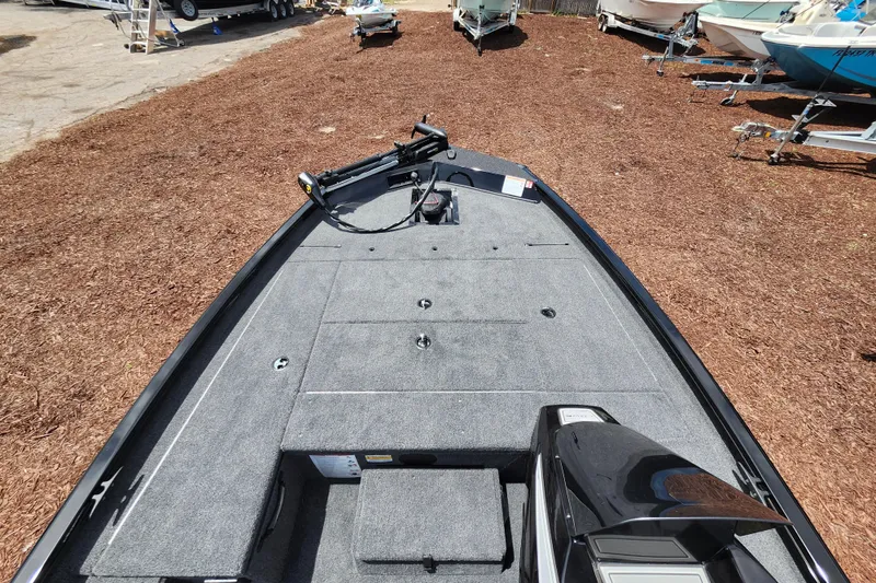 Slide: The Image of 2026 Lowe Stinger 175C boat with spacious deck, parked on mulch ground. - 22