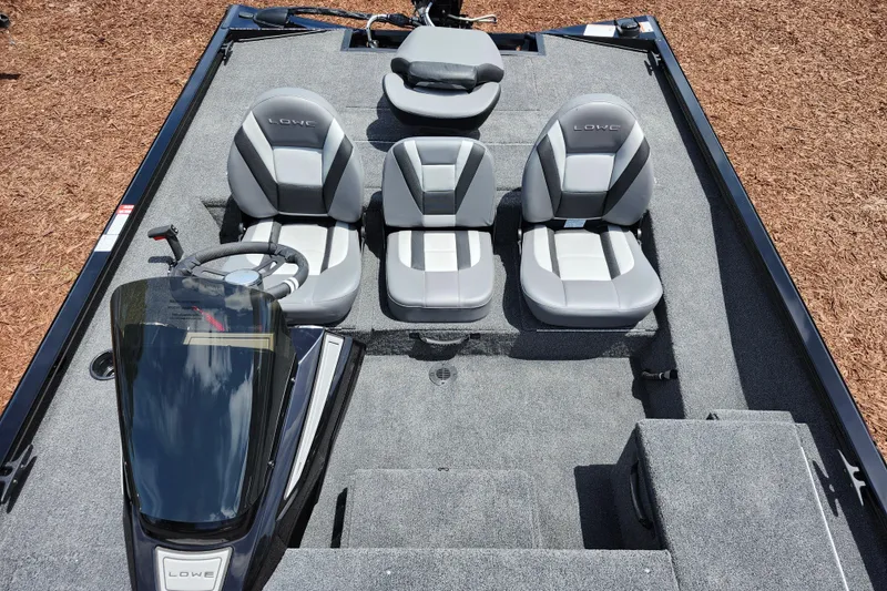 Slide: The Image of 2026 Lowe Stinger 175C boat interior with gray seating and steering console. - 24