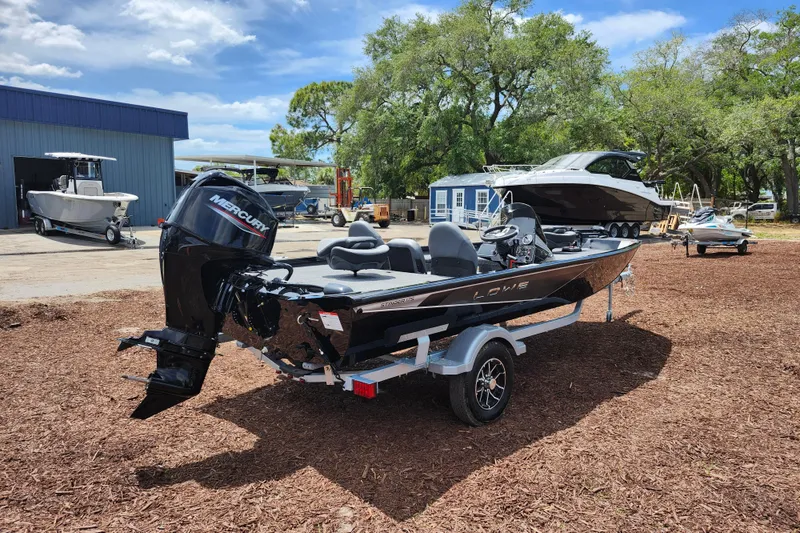 Slide: The Image of 2026 Lowe Stinger 175C boat with Mercury engine on a trailer, outdoors. - 4