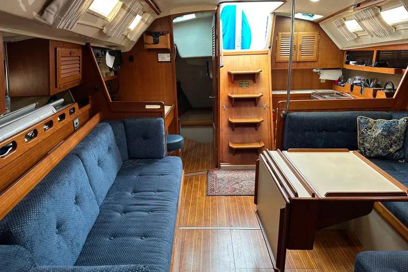 Slide: The Image of Interior of a 1987 O'Day 40 sailboat with wooden finishes and blue upholstery. - 10