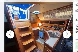 Slide: The Image of Interior of a 1987 O'Day 40 sailboat, featuring a compact kitchen and wooden cabinetry. - 2