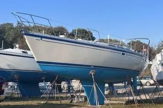 Slide: The Image of 1987 O'Day 40 sailboat on stands, white hull, blue bottom, outdoor storage. - 6