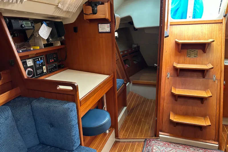 Slide: The Image of Interior of a 1987 O'Day 40 sailboat featuring wooden cabinetry and navigation station. - 9