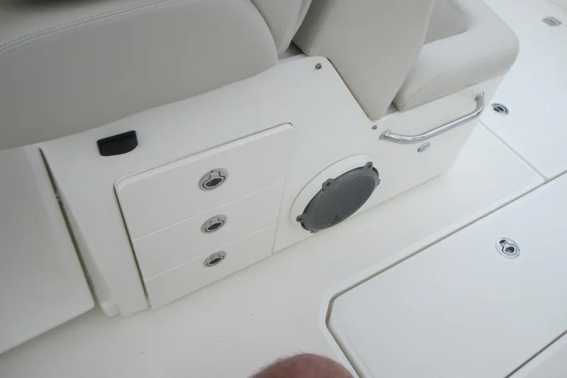 Slide: The Image of Interior view of a 2018 Boston Whaler 330 Outrage boat, featuring storage compartments and speaker. - 11
