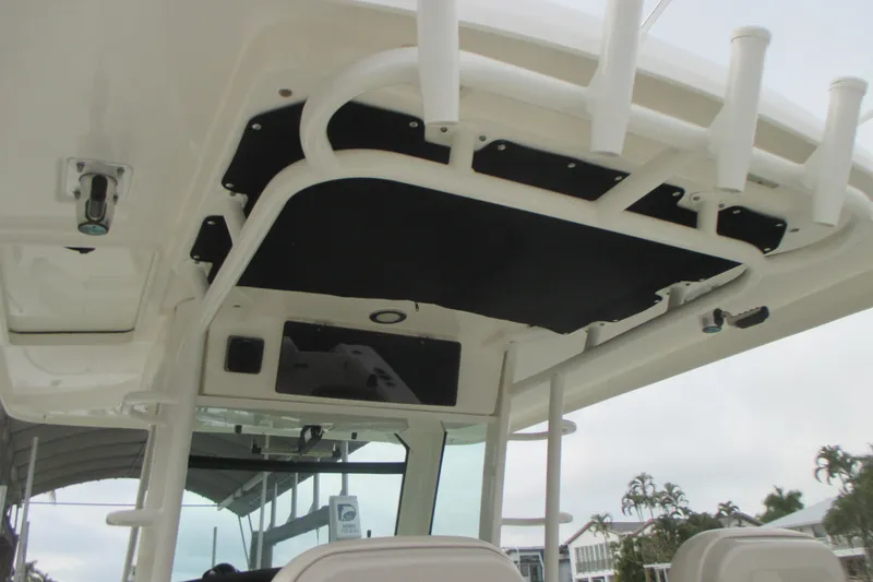 Slide: The Image of 2018 Boston Whaler 330 Outrage boat interior with rod holders and overhead storage. - 12
