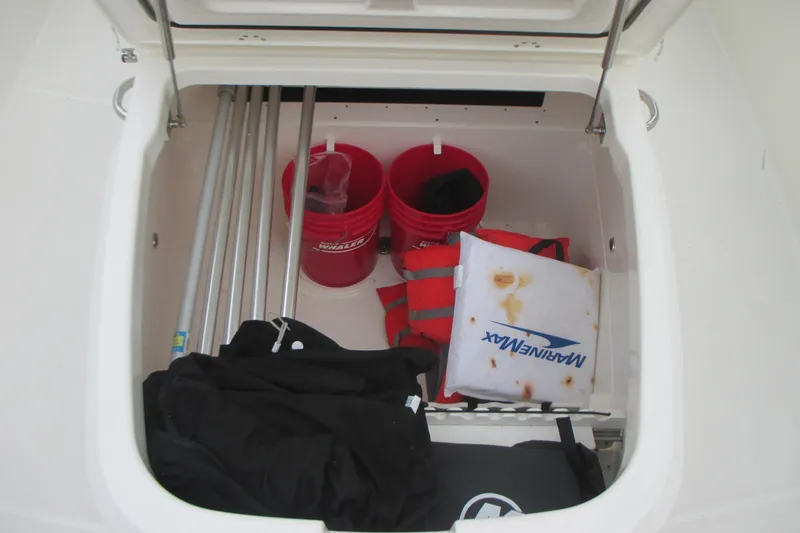 Slide: The Image of Storage compartment of 2018 Boston Whaler 330 Outrage with buckets and life jackets. - 22