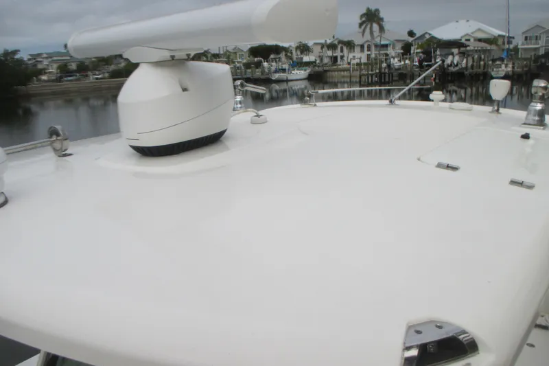 Slide: The Image of 2018 Boston Whaler 330 Outrage boat deck with radar, docked near waterfront homes. - 24