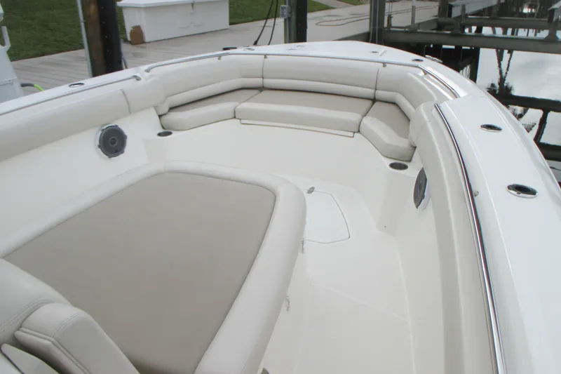 Slide: The Image of 2018 Boston Whaler 330 Outrage boat interior with cushioned seating and speakers. - 25
