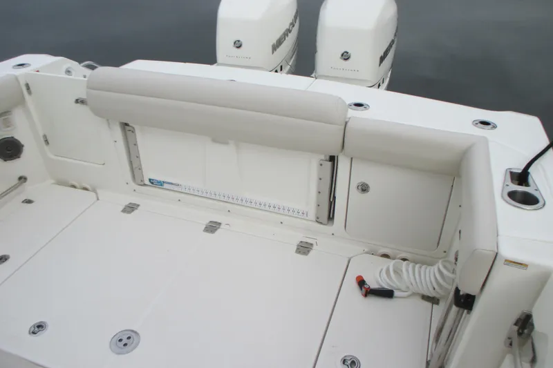 Slide: The Image of 2018 Boston Whaler 330 Outrage boat deck with seating and twin Mercury engines. - 6