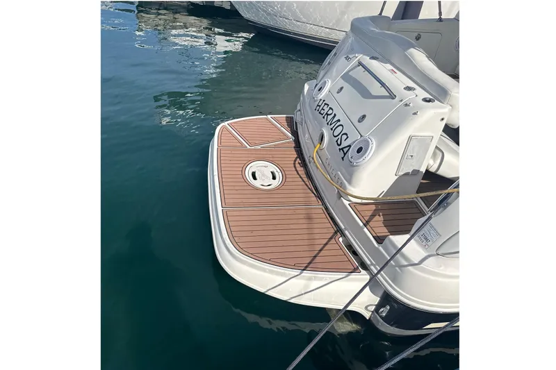 Slide: The Image of 2007 Sea Ray Sundancer 280 docked, featuring a sleek swim platform and elegant design. - 2