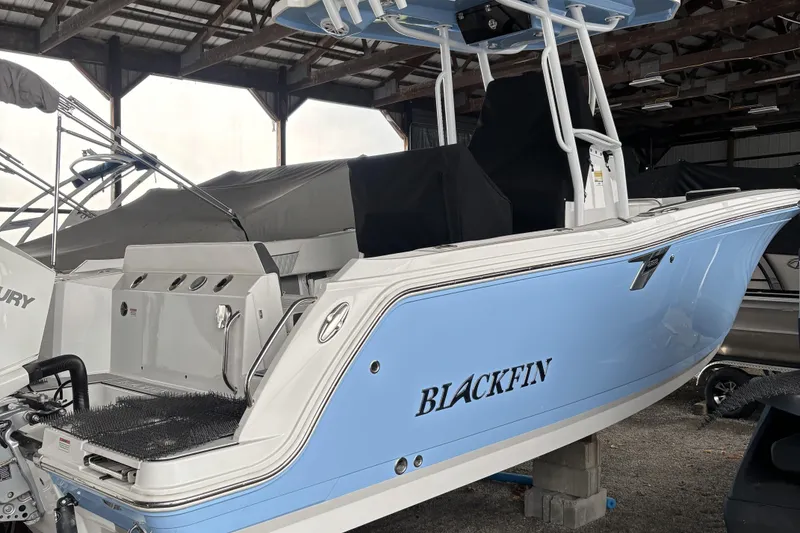 Slide: The Image of 2024 Blackfin 222 CC boat in storage, featuring a sleek blue and white design. - 2