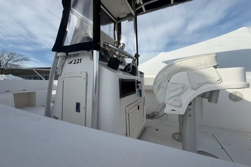 Slide: The Image of 1997 Mako 221 Center Console boat interior with helm and seating under blue sky. - 16