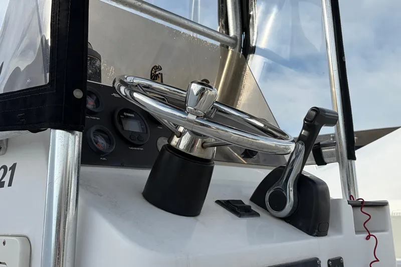 Slide: The Image of Steering console of a 1997 Mako 221 Center Console boat with gauges and controls. - 17