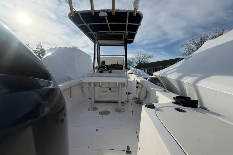 Slide: The Image of 1997 Mako 221 Center Console boat under a clear sky, docked and covered. - 8