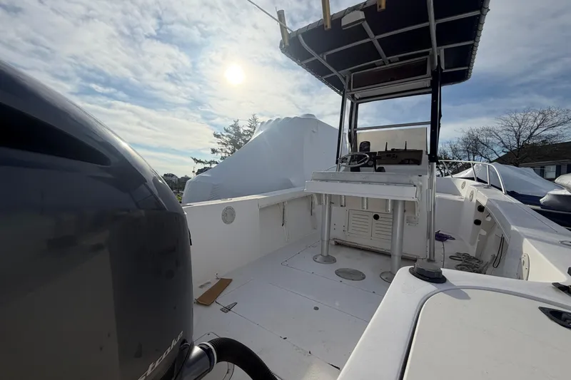 Slide: The Image of 1997 Mako 221 Center Console boat under a sunny sky, featuring a spacious deck. - 9