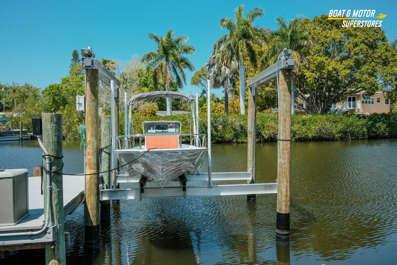 Slide: The Image of 1976 Boston Whaler 17 Montauk on lift, surrounded by tropical scenery and calm water. - 13