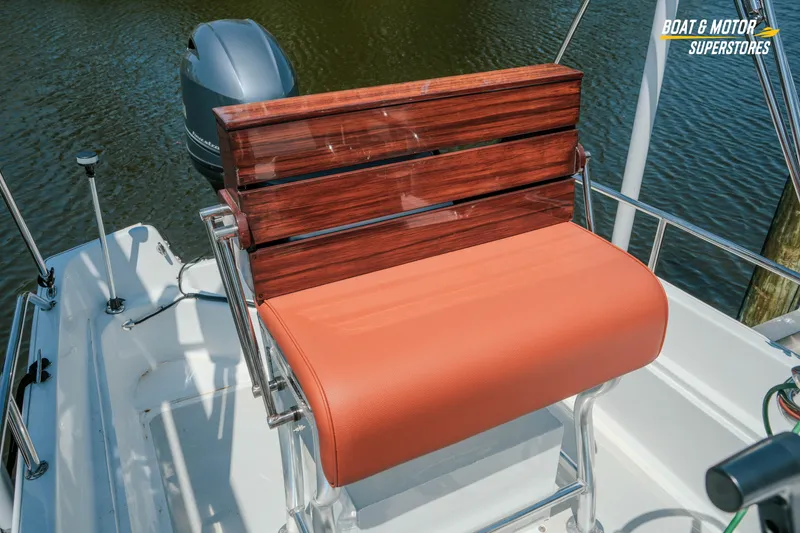 Slide: The Image of 1976 Boston Whaler 17 Montauk boat with wooden seat and orange cushion on water. - 19