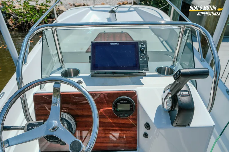 Slide: The Image of 1976 Boston Whaler 17 Montauk dashboard with steering wheel, Yamaha controls, and Simrad display. - 23