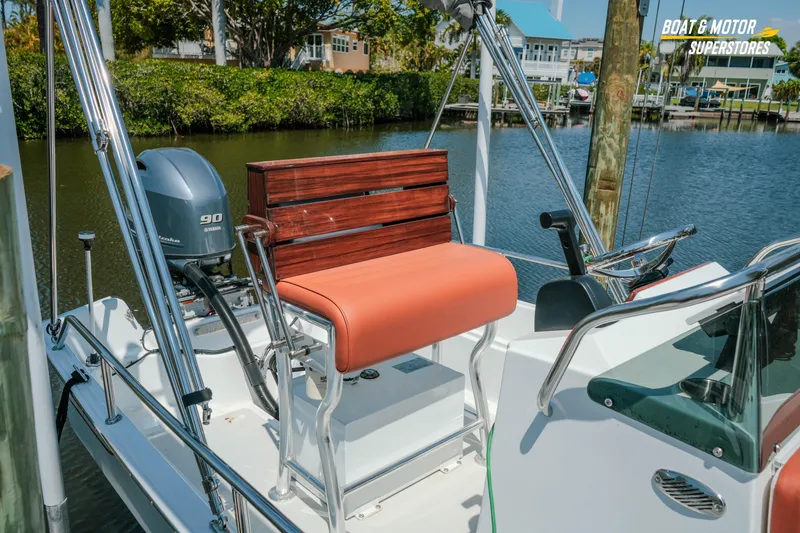 Slide: The Image of 1976 Boston Whaler 17 Montauk boat with Yamaha 90 engine, docked by a serene waterfront. - 3