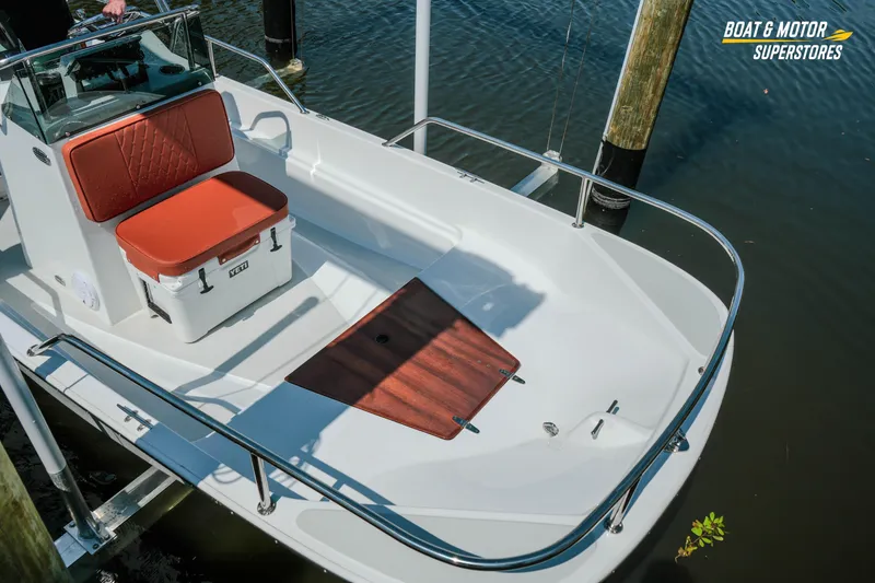 Slide: The Image of 1976 Boston Whaler 17 Montauk boat with red seating and cooler on calm water. - 32