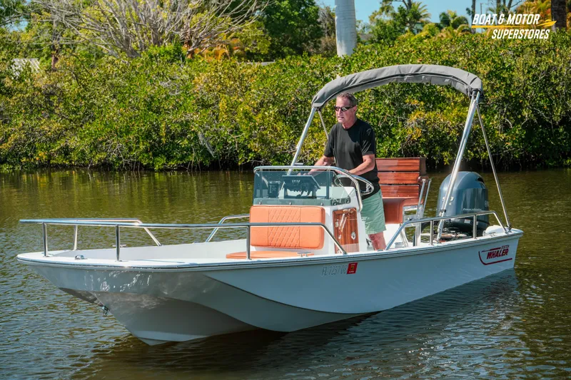 Slide: The Image of 1976 Boston Whaler 17 Montauk boat cruising on a calm river with lush greenery. - 35
