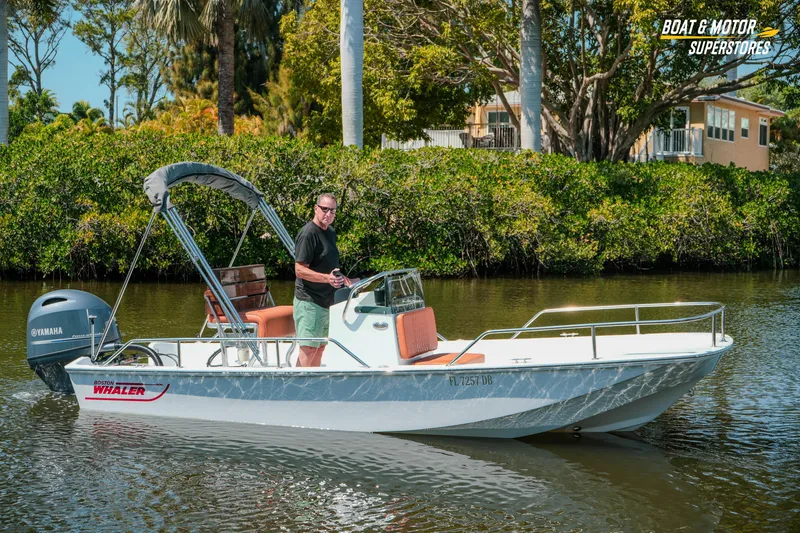 Slide: The Image of 1976 Boston Whaler 17 Montauk boat on calm water, featuring Yamaha motor and lush greenery backdrop. - 36