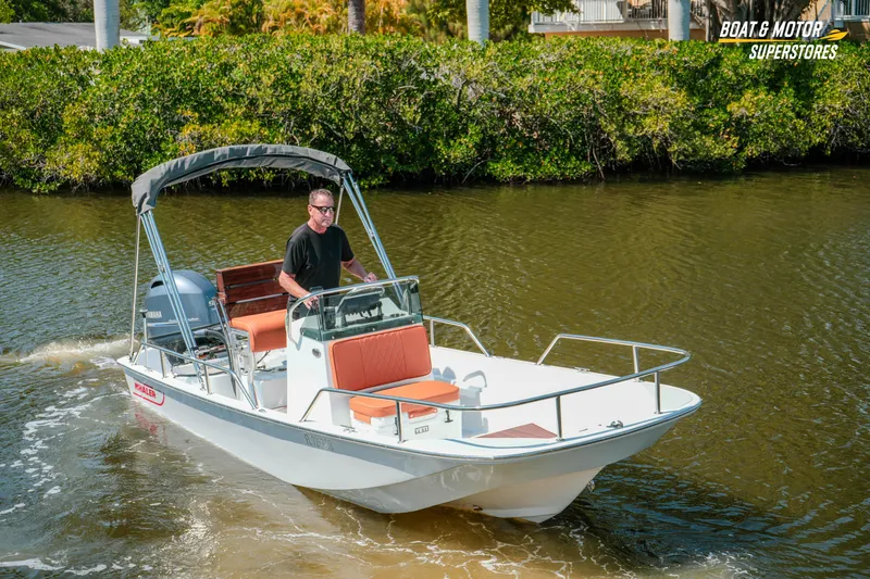 Slide: The Image of 1976 Boston Whaler 17 Montauk boat cruising on a calm river with lush greenery. - 39