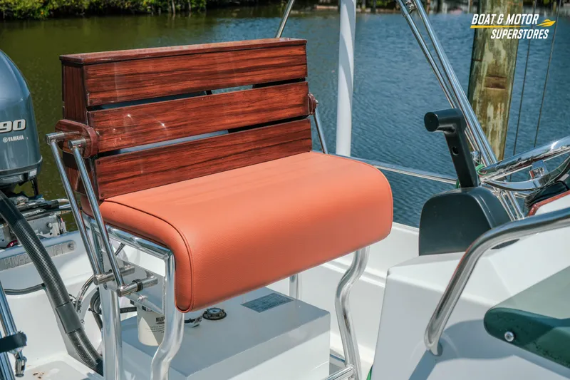 Slide: The Image of 1976 Boston Whaler 17 Montauk boat seat with wooden backrest and orange cushion. - 4