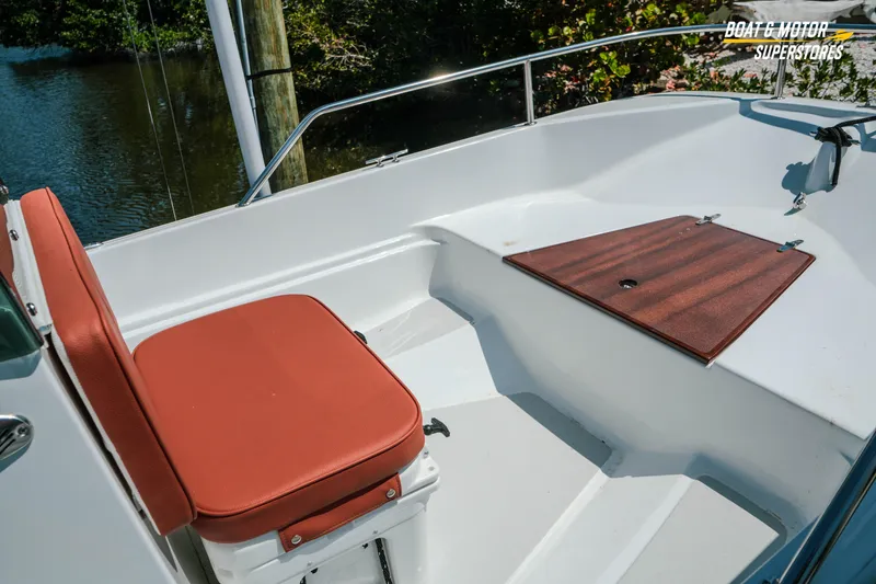 Slide: The Image of 1976 Boston Whaler 17 Montauk boat interior with red seating and wooden deck panel. - 7