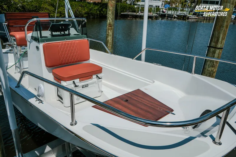 Slide: The Image of 1976 Boston Whaler 17 Montauk boat with red seating, docked by the water. - 8