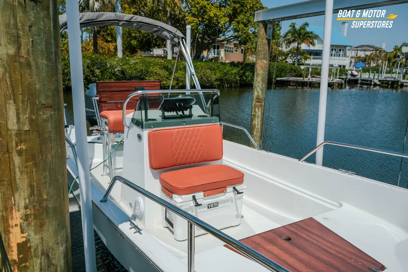 Slide: The Image of 1976 Boston Whaler 17 Montauk boat docked, featuring red cushioned seats and sleek design. - 9