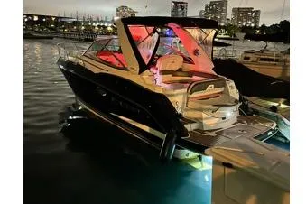 The Image of 2014 Monterey 295 Sport Yacht docked at night with city skyline. - 1
