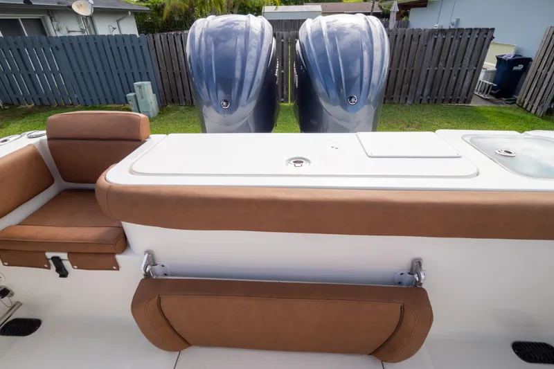 Slide: The Image of 2021 Sea Hunt Gamefish 27 boat interior with brown seating and dual engines. - 100