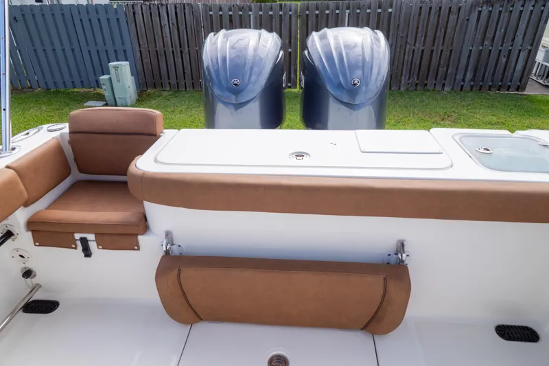 Slide: The Image of 2021 Sea Hunt Gamefish 27 boat with brown cushioned seating and white deck. - 102