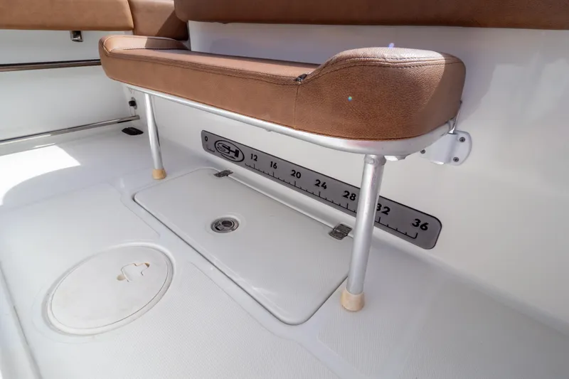 Slide: The Image of 2021 Sea Hunt Gamefish 27 boat interior with brown cushioned seating. - 105
