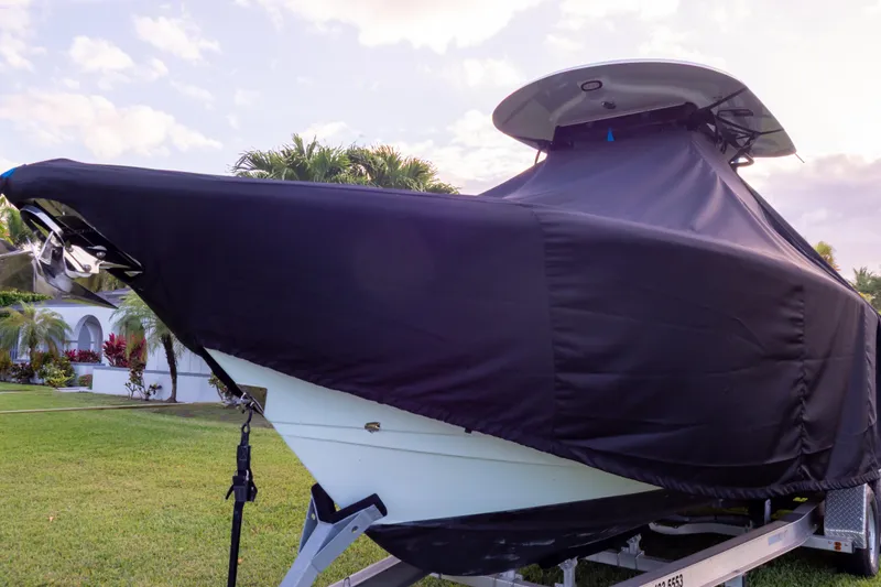 Slide: The Image of 2021 Sea Hunt Gamefish 27 boat covered, parked on a trailer in a grassy area. - 118
