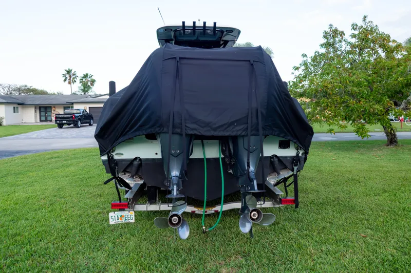 Slide: The Image of 2021 Sea Hunt Gamefish 27 boat covered on trailer, parked on grass. - 119