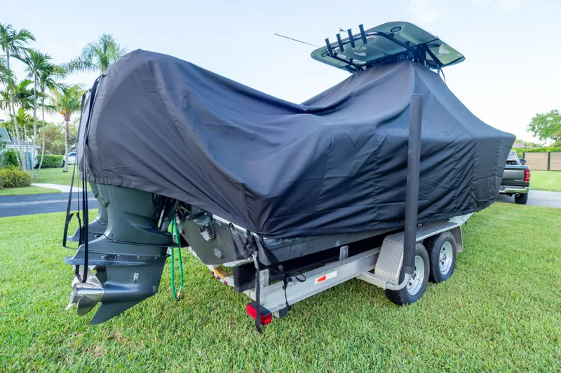 Slide: The Image of 2021 Sea Hunt Gamefish 27 boat with ladder and outboard motor on grass. - 121