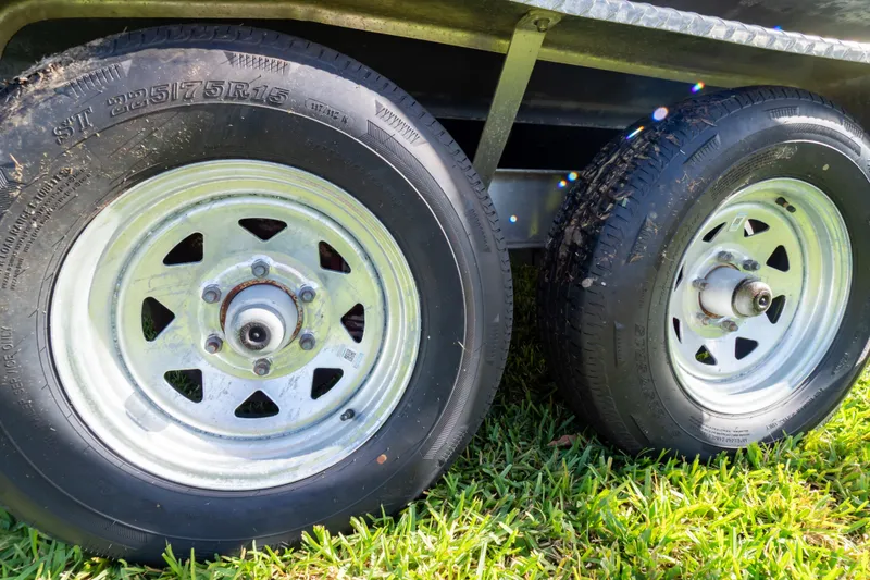 Slide: The Image of Trailer wheels of a 2021 Sea Hunt Gamefish 27 on grass. - 125