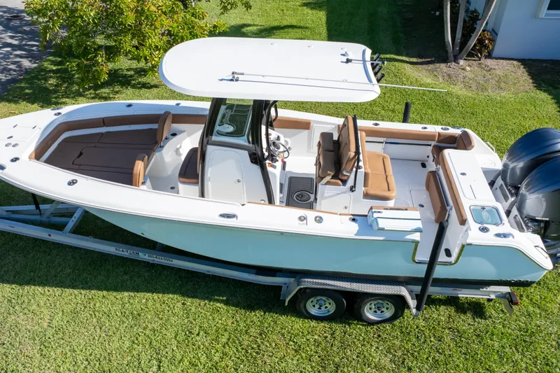 Slide: The Image of 2021 Sea Hunt Gamefish 27 boat with dual Yamaha engines, parked on a trailer. - 17