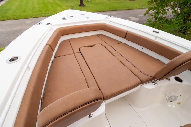 Slide: The Image of 2021 Sea Hunt Gamefish 27 Forward Seating with tan cushions on green grass. - 37