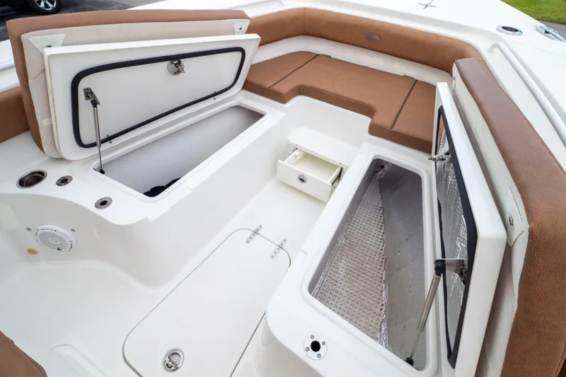 Slide: The Image of 2021 Sea Hunt Gamefish 27 Forward Seating storage compartment with brown cushioned seat. - 39