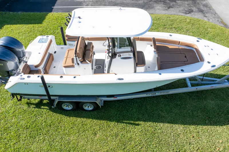 Slide: The Image of 2021 Sea Hunt Gamefish 27 boat on trailer, featuring forward seating and twin engines. - 52