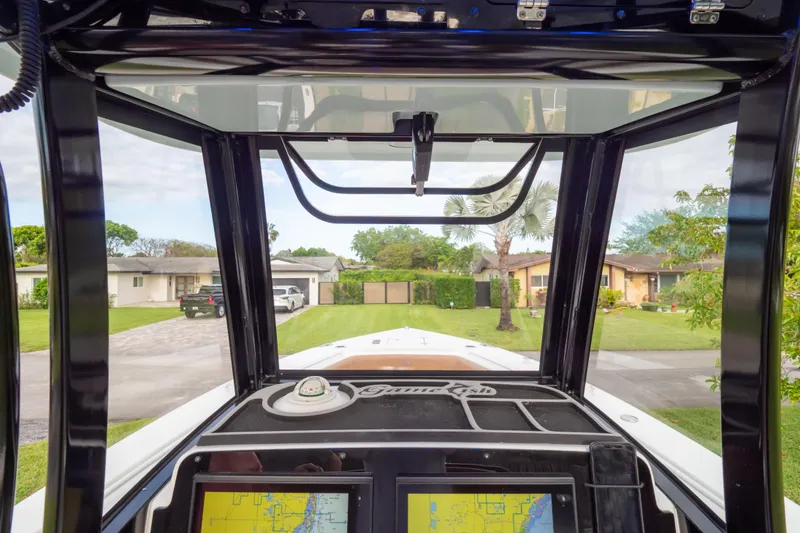Slide: The Image of 2021 Sea Hunt Gamefish 27 boat dashboard with navigation screens, parked in a residential area. - 53